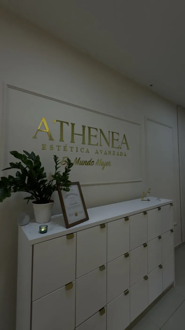 Pared de la entrada con el logo dorado de ATHENEA
